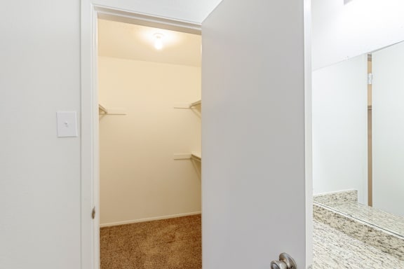 This is a photo of the walk-in closet in the primary bedroom in the 1245 square foot 2 bedroom, 2 bath apartment at Cambridge Court Apartments in Dallas, TX.