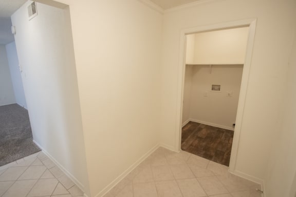 This is a photo of the entryway and closet with washer and dryer connections (available in select apartments) of a 612 square foot 1 bedroom apartment at Cambridge Court Apartments in Dallas, TX.
