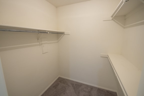 This is a photo of the master bedroom walk-in closet of a 1086 square foot 2 bedroom  apartment at Cambridge Court Apartments in Dallas, TX.