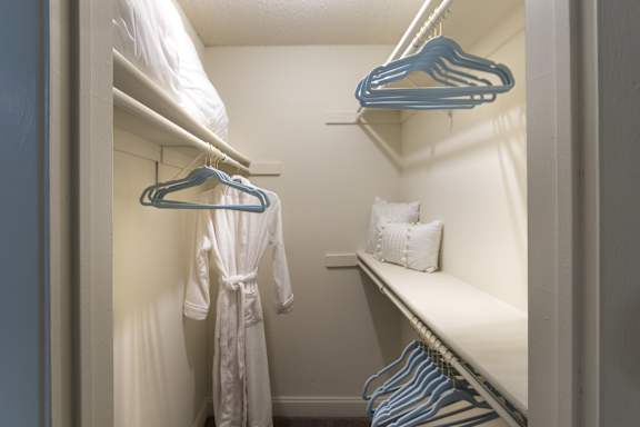 Walk-in closet in a 1-bedroom apartment at Cambridge Court Apartments in Dallas, Texas, showing built-in shelving and hanging space.