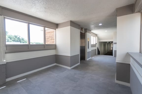 This is a photo of an elevatorin an open air hallway with new tile in the 450 square foot efficiency apartment at Cambridge Court Apartments in Dallas, TX.