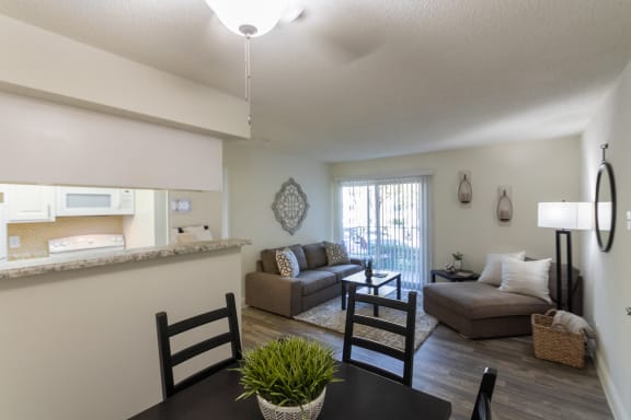This is a photo of the living room from the dining area of the 515 square foot 1 bedroom apartment at Canyon Creek Apartments in Dallas, TX