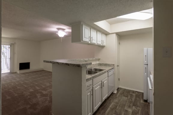 This is a photo of the kitchen and dining areas of the 880 square foot 2 bedroom, 2 bath apartment at Canyon Creek Apartments in Dallas, TX