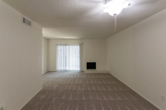 This is a photo of the living room from the dining area of the 880 square foot 2 bedroom, 2 bath apartment at Canyon Creek Apartments in Dallas, TX