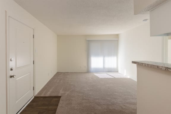 This is a photo of the living room from the dining area in a 515 square foot 1 bedroom, 1 bath apartment at Canyon Creek Apartments in Dallas, TX