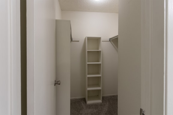 This is a photo of the bedroom walk-in closet with built-in shelving in a 717 square foot 1 bedroom, 1 bath apartment at Canyon Creek Apartments in Dallas, TX