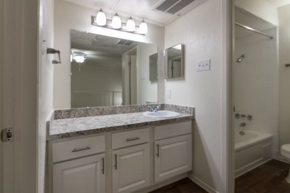 This is a photo of the bath vanity and shower in a 717 square foot 1 bedroom, 1 bath apartment at Canyon Creek Apartments in Dallas, TX