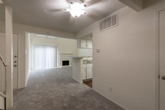 This is a photo of the living room from the dining room in a 717 square foot 1 bedroom, 1 bath apartment at Canyon Creek Apartments in Dallas, TX