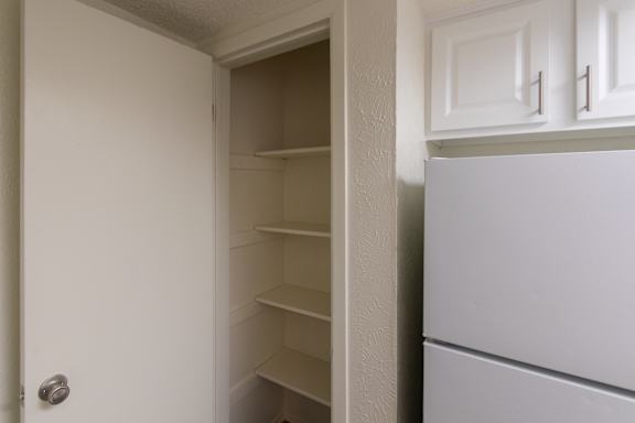 The kitchen pantry in a 717 square foot 1 bedroom, 1 bath loft apartment home at Canyon Creek Apartments in Dallas Midtown neighborhood of Dallas, TX.