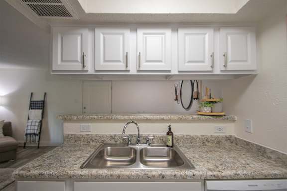 View of the dining room from the kitchen of a 515 square foot 1 bedroom, 1 bath apartment home at Canyon Creek Apartments in Dallas Midtown neighborhood of Dallas, TX.