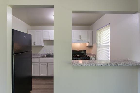 Kitchen and breakfast bar view inside a two-bedroom, two-bath apartment at Compton Lake Apartments