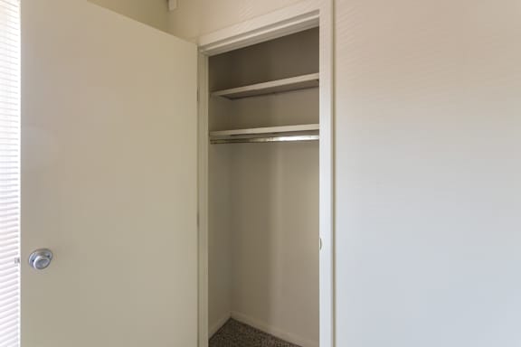 LIving room closet with hanging rod and upper shelf in an 880-square-foot apartment home