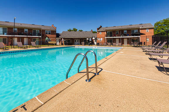 Outdoor swimming pool with sundeck seating at Compton Lake Apartments in Mount Healthy, Ohio