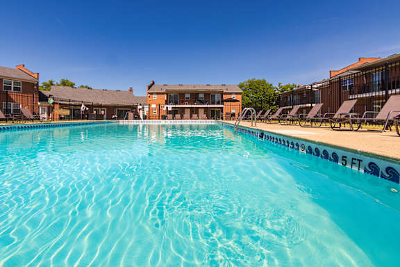 inviting swimming pool and lounge chairs at Compton Lake Apartments on a sunny day