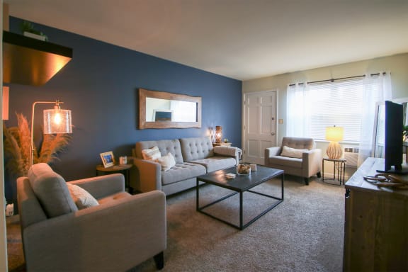 This is a photo of the living room room of the 550 square foot 1 bedroom, 1 bath, balcony floor plan model apartment at College Woods Apartments in Cincinnati, OH.