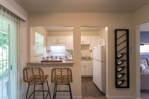 This is a photo of the kitchen with pass through breakfast bar of the 550 square foot 1 bedroom, 1 bath, balcony floor plan model apartment at College Woods Apartments in thne NOrth College Hill neighborhood of Cincinnati, OH.