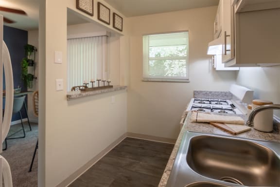 This is a photo of the kitchen with pass through breakfast bar of the 550 square foot 1 bedroom, 1 bath, balcony floor plan model apartment at College Woods Apartments in thne NOrth College Hill neighborhood of Cincinnati, OH.