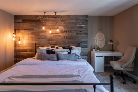 This is a photo of the bedroom with barb wood wall in the upgraded 650 square foot, 1 bedroom, 1 bath model apartment at Deer Hill Apartments in Cincinnati, Ohio.