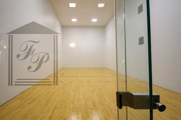 A room with a wooden floor and a glass door with a lock on it.