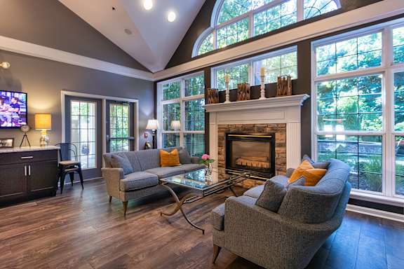 A living room with a grey couch and a fireplace  at Fairfield Pointe Apartments in Fairfield, Ohio.