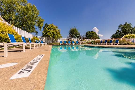 A pool surrounded by blue lounge chairs at Fairfield Pointe Apartments in Fairfield, Ohio.