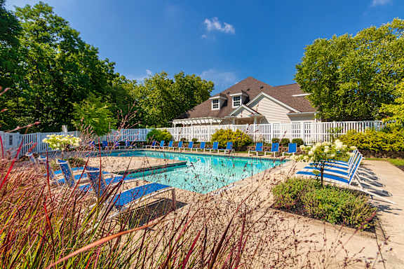 A pool surrounded by blue lounge chairs at Fairfield Pointe Apartments in Fairfield, Ohio.