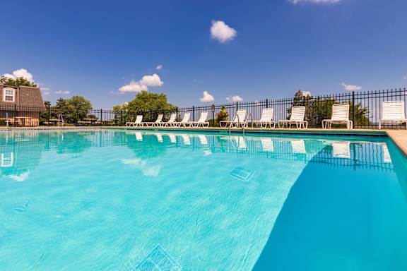 A pool surrounded by white lounge chairs at Fairfield Pointe Apartments in Fairfield, Ohio.