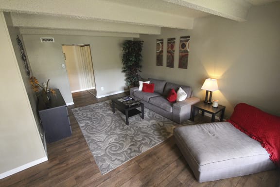This is a photo of the available hardwood vinyl flooring in the living room in the 653 square foot 1 bedroom apartment at Harvard Square Apartments, in Dallas, TX.