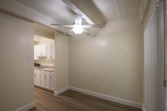 A dining room with a white ceiling fan in a 1 bedroom, 1 bath apartment home at Harvard Square Apartments in the Vickery Midtown neighborhood of Dallas, TX.