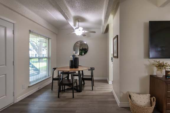 Dining area and living room view with large window in a one-bedroom apartment home at Harvard Square Apartments