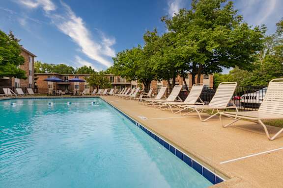 A large swimming pool with sun loungers on the side at Blue Grass Manor Apartments in Erlanger, KY.