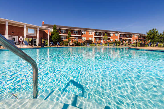 Pool entry handrail and clear water at the inviting community swimming pool at Lake of the Woods Apartments