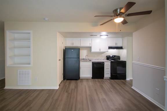 This is a photo of the kitchen and living room with built-in bookshelf of the 560 square foot 1 bedroom, 1 bath Elm floor plan at Montana Valley Apartments in Cincinnati, OH.