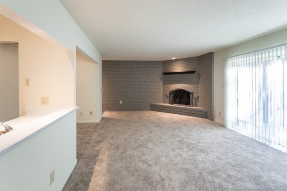 This is a photo the living room with brick wall and wood-burning fireplace of the 925 square foot, Hazelnut 2 bedroom, 1 bath apartment at Montana Valley Apartments in the Westwood neighborhood of Cincinnati, OH.