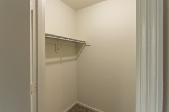 This is a photo of one of the 2 walk-in closets in the primary bedroom of the 1310 square foot 3 bedroom, 1.5 bath Pine floor plan at Montana Valley Apartments in Cincinnati, OH.