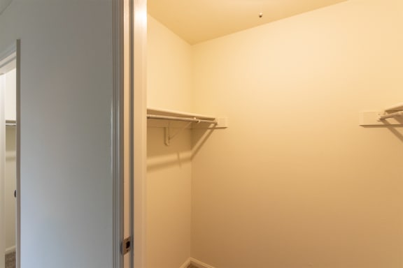 This is a photo of one of the 2 walk-in closets in the primary bedroom of the 1310 square foot 3 bedroom, 1.5 bath Pine floor plan at Montana Valley Apartments in Cincinnati, OH.