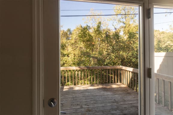 This is a photo of the private back deck from the living room of the 1310 square foot 3 bedroom, 1.5 bath Pine floor plan at Montana Valley Apartments in Cincinnati, OH.