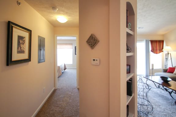 This is a photo of the hallway to the primary bedroom and built-in living room shelving in the 1242 square foot, 2 bedroom Atlantic floor plan at Nantucket Apartments in Loveland, OH.