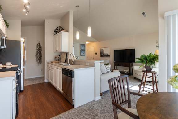 A modern kitchen with white cabinets and a black fridge.