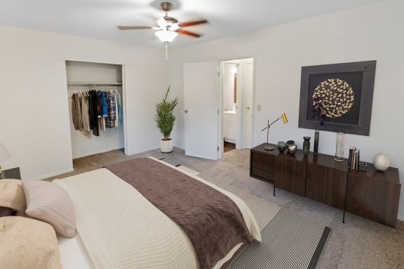 This is a photo of the digitally staged primary bedroom of a 742 square foot, 2 bedroom apartment at Romaine Court Apartments in Cincinnati, Ohio.