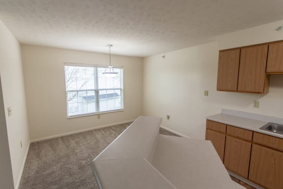This is photo of the breakfast bar looking into the dining room in the 852 square foot, 1 bedroom Fairlawn floor plan at Trails of Saddlebrook Apartments in Florence, KY.