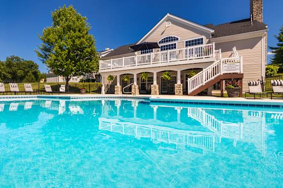 A house with a pool in front of it.