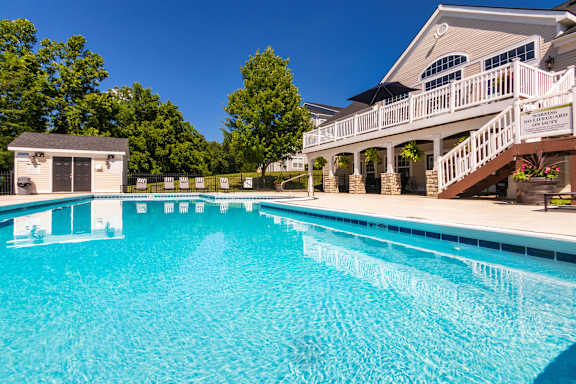 A large swimming pool in front of a house.