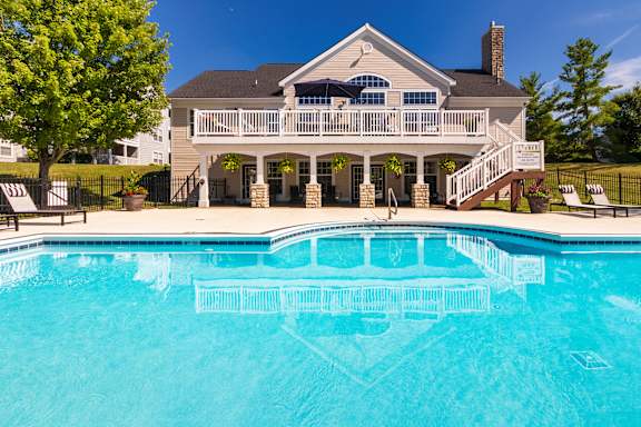A house with a pool in front.