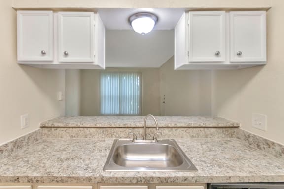 This is a photo of the kitchen looking into the living room in the 558 square foot 1 bedroom apartment at The Summit at Midtown Apartments in Dallas, TX.