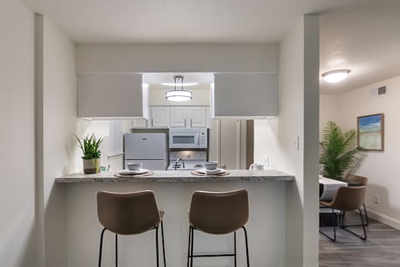 Breakfast bar with seating overlooking the kitchen and living area at The Summit at Midtown in Dallas, TX