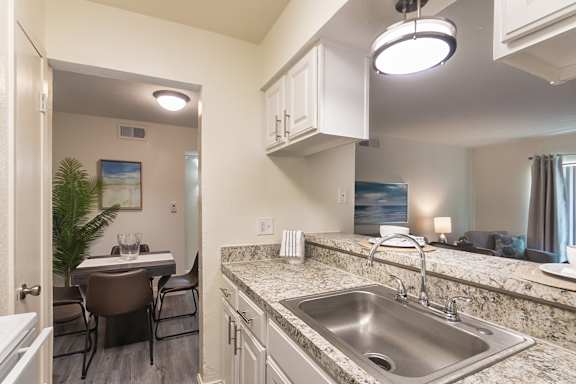 Kitchen pass-through and granite-style breakfast bar overlooking the dining and living area at The Summit at Midtown