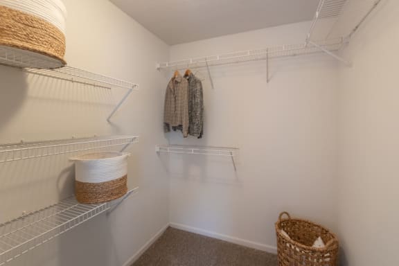 This is a photo of the primary bedroom walk-in closet of the 890 square foot 2 bedroom, 2 bath Liberty at Washington Place Apartments in in Miamisburg, Ohio in Washington Township.