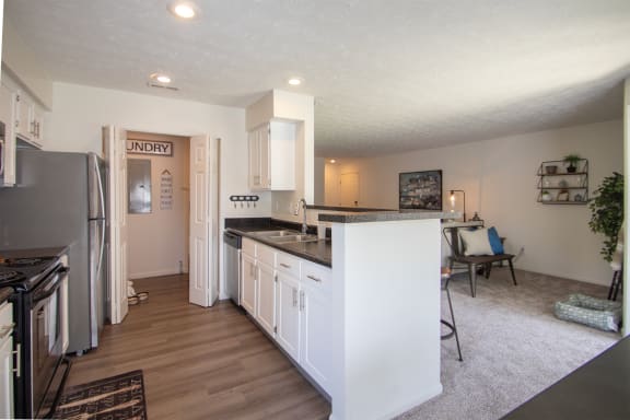 This is a photo of the kitchen and living room of the 1100 square foot 2 bedroom Kettering floor plan at Washington Park Apartments in Centerville, OH.