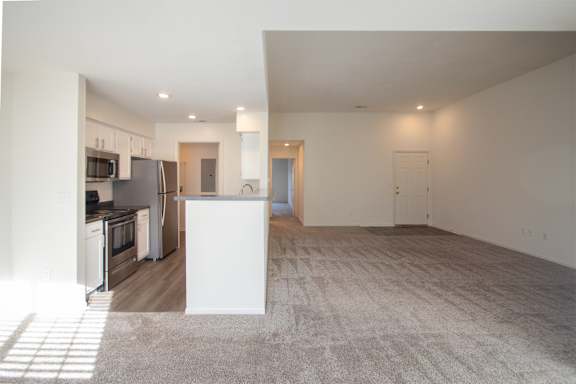 This is a photo of the kitchen and living room from the dining room of the 900 square foot 2 bedroom Miamisburg floor plan at Washington Park Apartments in Centerville, OH.